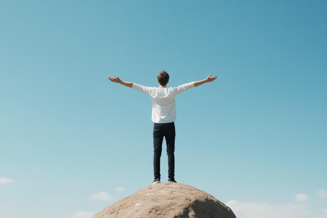 Bild von Mann mit ausgestreckten Armen auf einem Berg