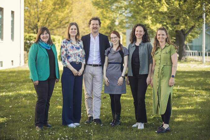 Ein Foto mit sechs Personen, fünf Frauen und ein Mann. Alle lächeln in die Kamera.