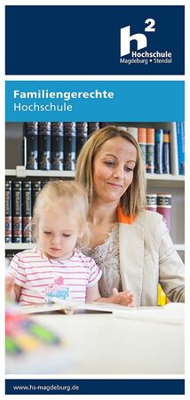 Eine Mutter sitzt arbeitend und mit ihrer Tochter auf dem Schoß in der Bibliothek.