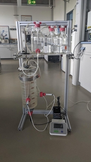 Glasflaschen und Messzylinder mit Sonden und Messgeräten in einem Labor