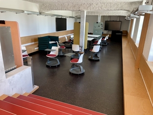 eine Raum mit bunten Stühlen und Tischen