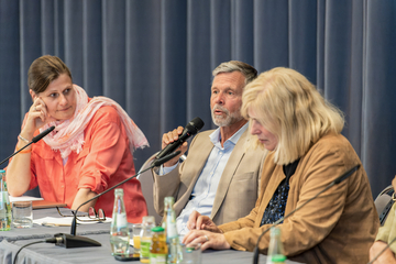 drei Menschen im Podium