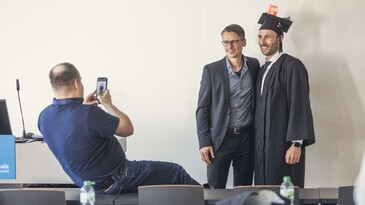 Ein frisch promovierter Doktorand feiert nach einer erfolgreichen Disputation an der Hochschule Magdeburg-Stendal mit seinem Betreuer