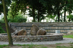 Blick in das grüne Klassenzimmer mit Sitzbänken und Springbrunnen
