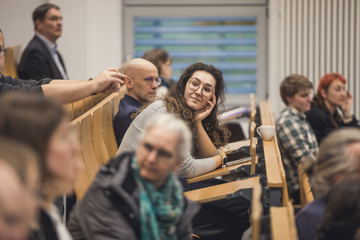 Teilnehmende der Veranstaltung verfolgen einen Vortrag im Hörsaal.