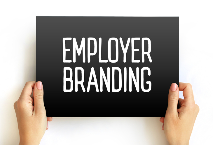 Hände halten ein schwarzes Schild mit der Aufschrift „Employer Branding“