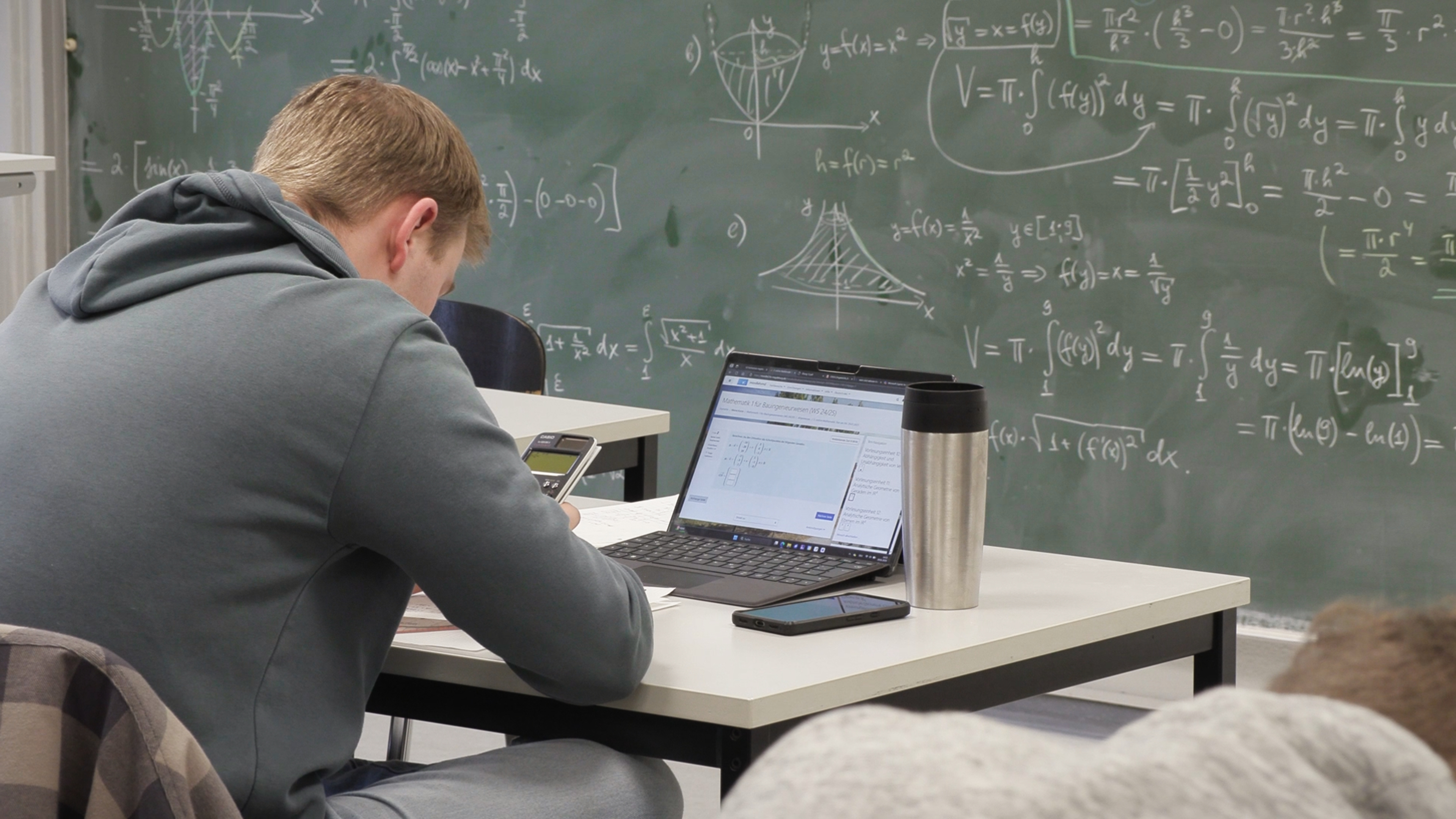 Das Bild zeigt einen Studierenden der digitale Mathematik-Aufgaben an einem PC löst.